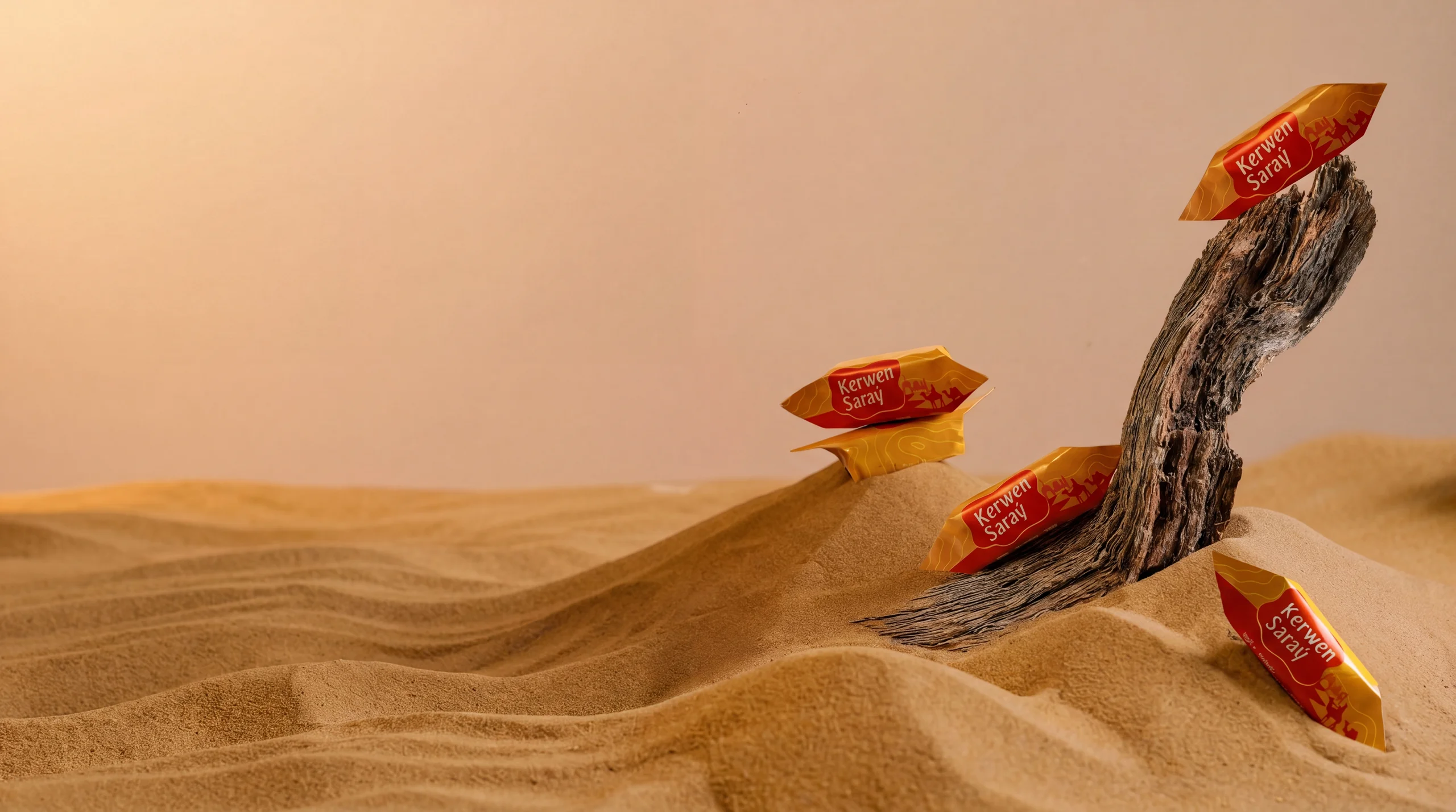 Kerwen Saray wrapped candies on desert sand with driftwood